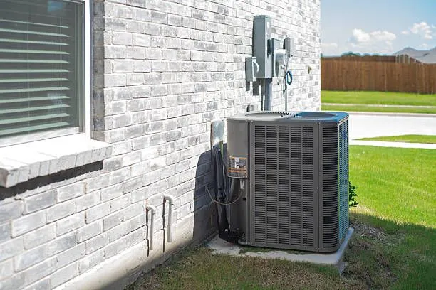 A new condenser installed beside a brick home
