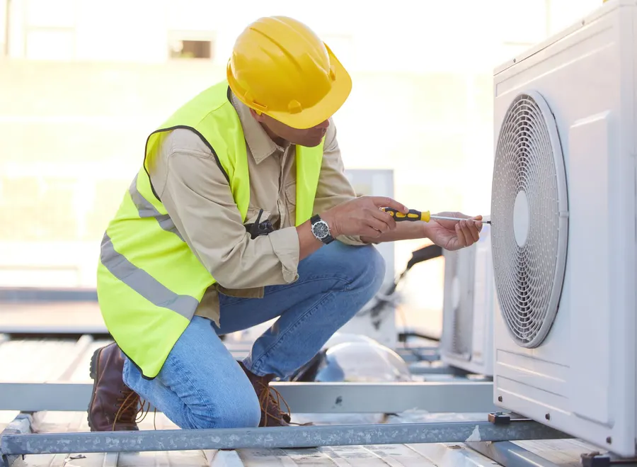 A technician servicing a rooftop unit