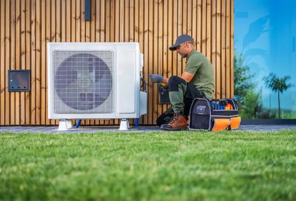 A technician servicing a mini split outdoor unit